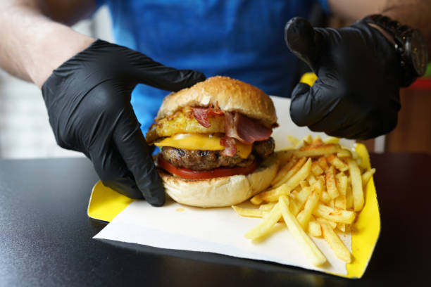 istock Hand taking a delicious burger with pineapple and bacon, ready to be enjoyed 1178425422