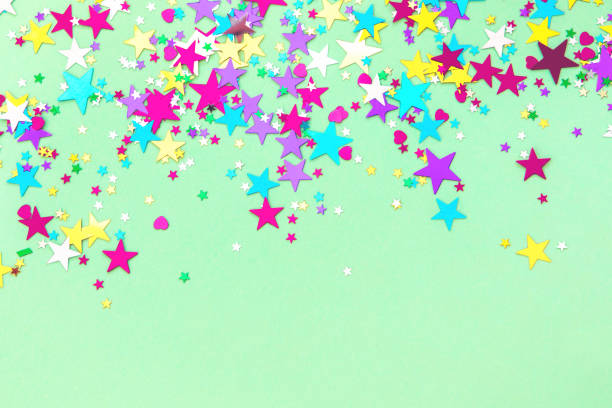 Sparkling golden glitter abstract background purple blue yellow desaturated color, fluid defocused, macro. Sequins sparkling over foil silver stars. party festive celebration background