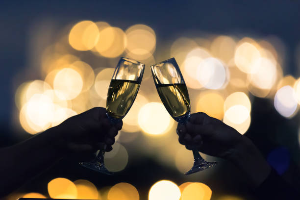밤 도시에서 음료를 마시는 커플 - champagne toast wine restaurant 뉴스 사진 이미지