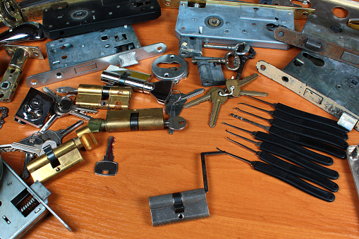Locksmith workshop. Keys, locks and picklocks on the table.