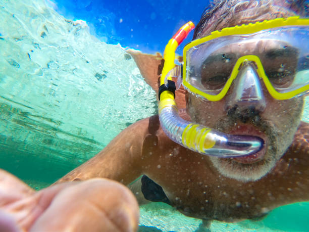 istock Mature Man Snorkeling and Taking Selfie Underwater 1178445300