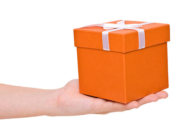Hand holding orange gift box. stock photo