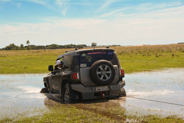 Rear view of a bogged 4x4 car being winched Rear view of a bogged Trolle being winched. Arambaré/Rio Grande do Sul/Brazil. cable winch stock pictures, royalty-free photos & images