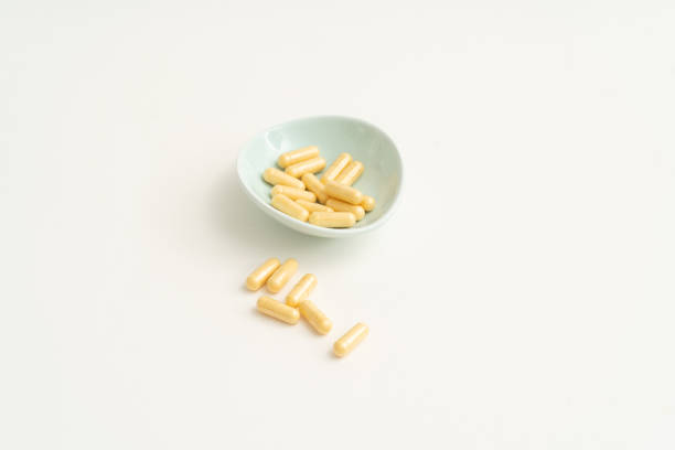 istock Yellow capsule pills on white background 1178450237