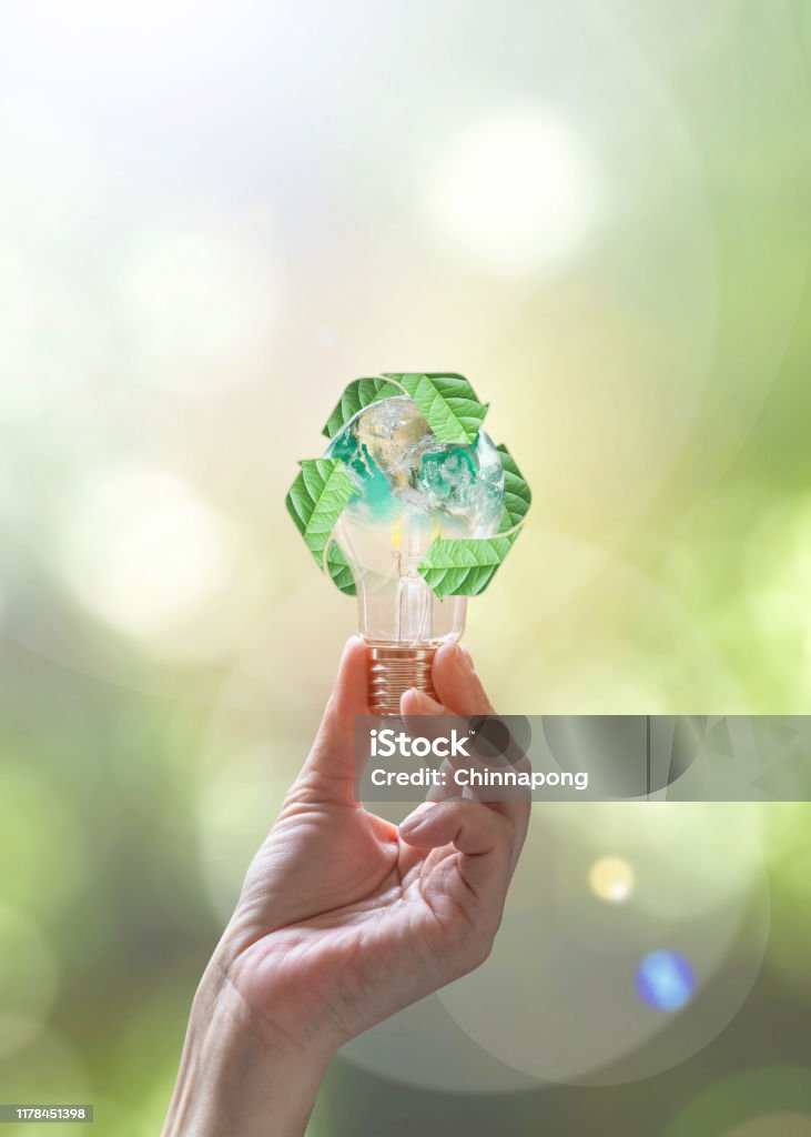 Ecology, energy saving, renewable, waste management and sustainable development concept with lightbulb with recycle leaves environmental protection symbol in people hand Sustainable Lifestyle Stock Photo