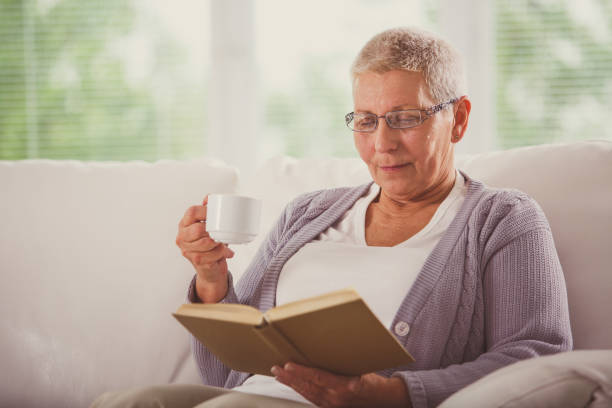 istock Senior woman enjoying a cup of coffee while reading a book 1178451613