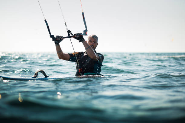 uomo adulto in mare con un aquilone e una tavola - wakeboarding surfing men vacations foto e immagini stock