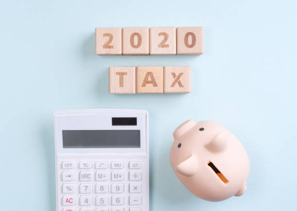 istock Abstract 2020 financial goal design concept - geometric wood blocks cubes on blue table background with piggy bank. 1178458329