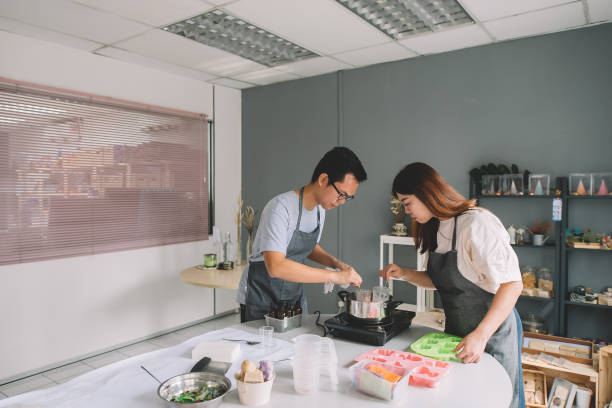 istock 2 asian chinese female and male working on handmade soap making workshop in a studio and mixing the raw material and cooking it 1178463481