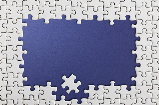 White jigsaw over blue background