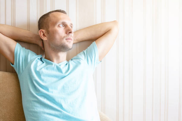 istock the guy is resting at home on the sofa with his hands behind his head 1178466373