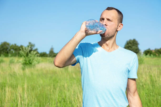 istock young man in nature drinks water from a bottle 1178466377