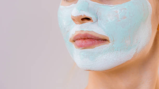 istock Girl with white green mud mask on face 1178476206