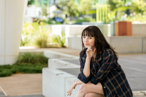 istock Young Woman Sitting on Concrete Steps In Park 1178480109