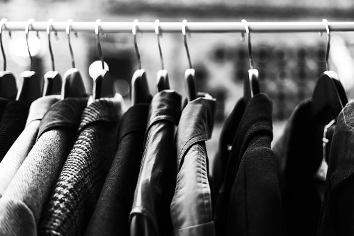 Clothes on the hangers at the flea market, discounts low prices clothing concept, image with soft focus
