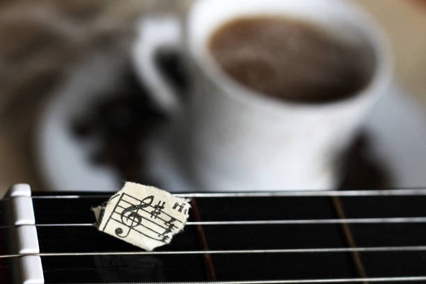 istock Guitar strings, torn paper notes and a Cup of coffee, music 1178487440