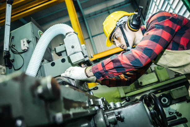 istock Asian worker wering the goggle, helmet, ear muff equipment in production plant using machine on the factory shop floor 1178487629