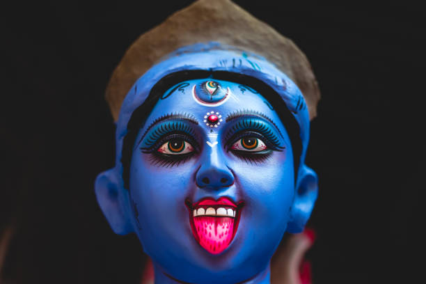Hindu Festival Sculptor. Close up of goddess Kali blue idol face with dark background. Sculptor of a Hindu god. kali statue stock pictures, royalty-free photos & images