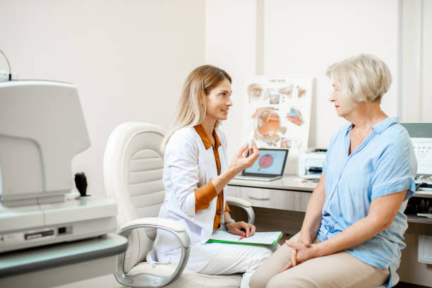 Senior patient with ophthalmologist in the office Senior woman patient talking with female ophthalmologist during a medical consultation at the ophthalmologic office. Doctor offering eye medcine for a patient eye care professional stock pictures, royalty-free photos & images