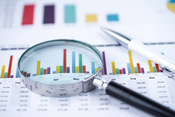 istock Magnifying glass on charts graphs spreadsheet paper. Financial development, Banking Account, Statistics, Investment Analytic research data economy, Stock exchange trading, Business office company meeting concept. 1178491838