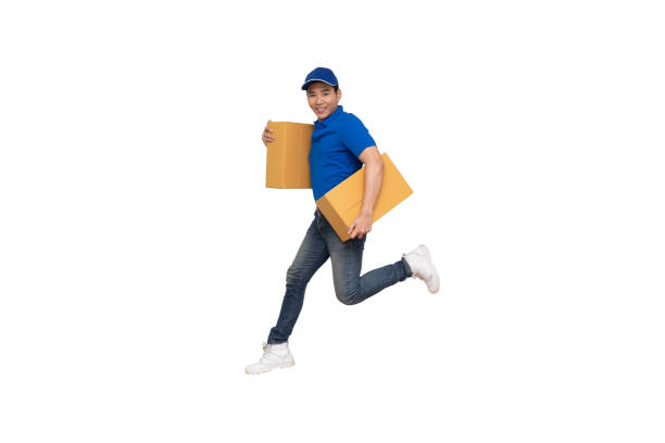 istock Energetic young Asian delivery man jumping and holding boxes isolated on white background, Deliveryman with parcel post box and fast shipping concept 1178493172