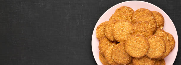 istock Cereal cookies on a pink plate on a black background, top view. Flat lay, overhead, from above. Copy space. 1178493192
