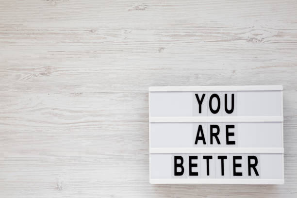 istock 'You are better' words on a lightbox on a white wooden surface, top view. Overhead, from above. Flat lay. Space for text. 1178493317