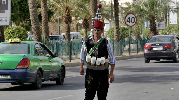 un venditore di tè che indossa abiti tradizionali arabi per le strade di amman, giordania - jordan amman market people foto e immagini stock