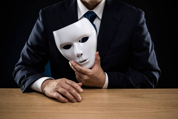istock Man in a suit removes his mask 1178499388