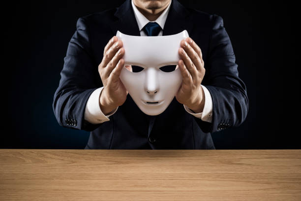 istock Man in a suit removes his mask 1178499442