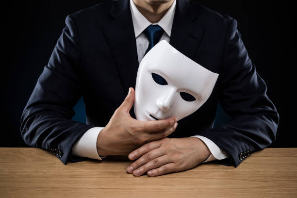 istock Man in a suit removes his mask 1178499463