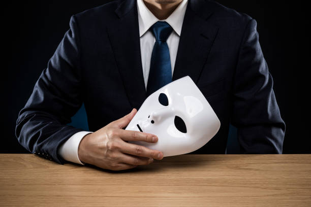 istock Man in a suit removes his mask 1178499474