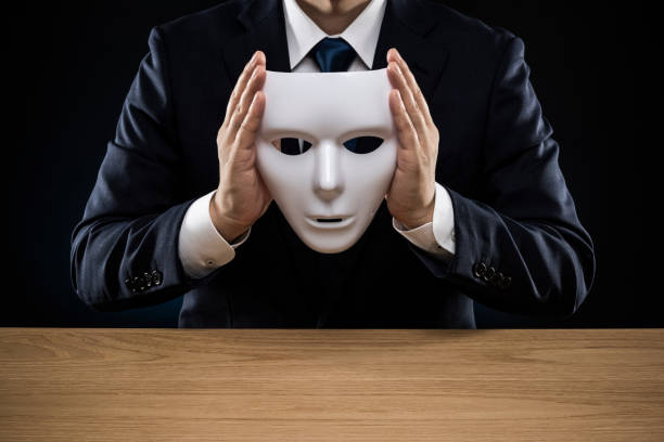 istock Man in a suit removes his mask 1178499490