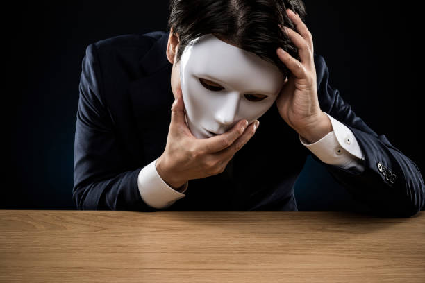 istock Man in a suit removes his mask 1178499516