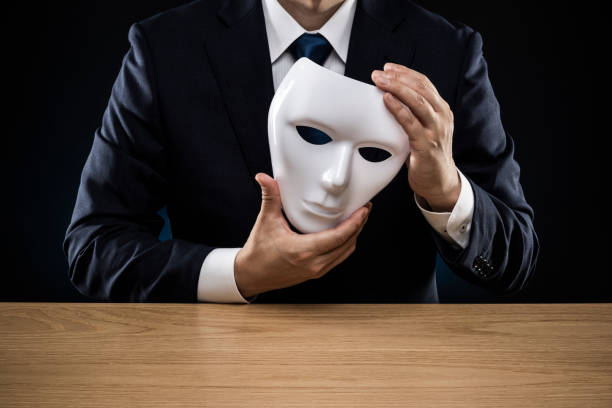istock Man in a suit removes his mask 1178499533