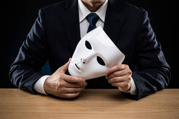 istock Man in a suit removes his mask 1178499546