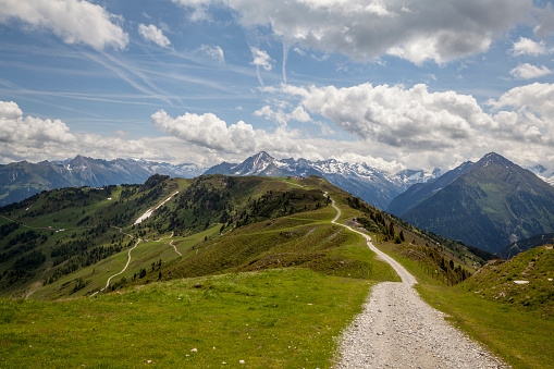 Hiking path near Penkenbahn summit station in summer, with snow-capped peaks in the background, near Mayrhofen in Tyrol, Austria
