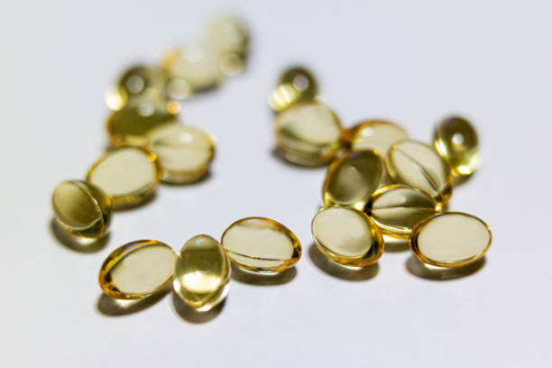 photos de proximité de pilules ou de vitamines - vitamin d capsule fish oil yellow photos et images de collection