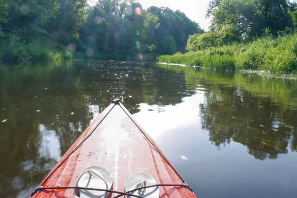 istock sun rays and kayak, red plastic kayak on the water 1178510027