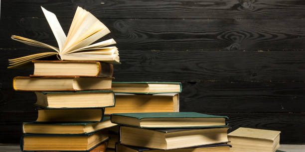 istock Open book, hardback books on wooden table. Back to school. Copy space 1178513889