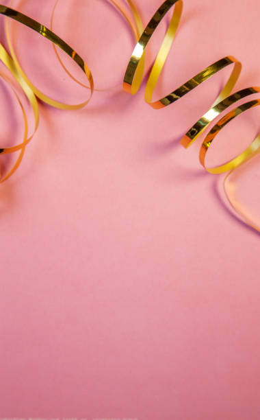 istock Pink background with golden curled ribbon strip 1178514460