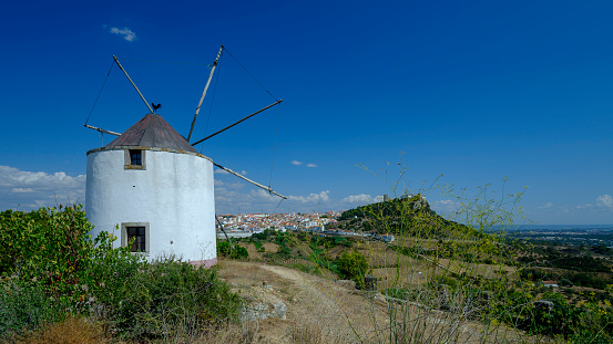 Palmela, Portugal - September 15, 2019:  Windmills on a hill crest in the Parque Natural da Arrabida, near Setubal in Portugal
