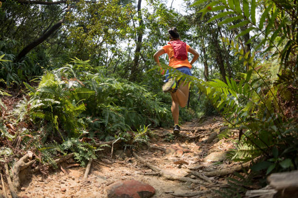 istock Woman ultra marathon runner running on tropical forest trail 1178515856