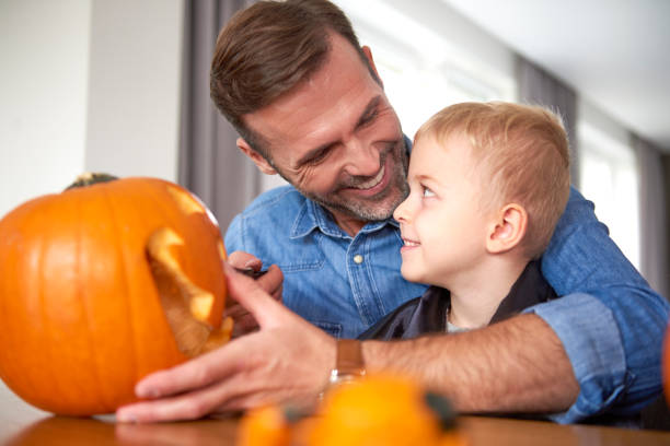 istock Father and son making carved pumpkin 1178517953