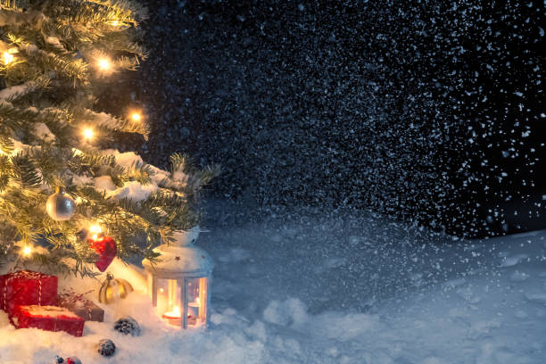 istock Christmas composition - gifts and a lantern in the snow under a Christmas tree decorated with lights and Christmas-tree decorations, copy space, place for text 1178519317