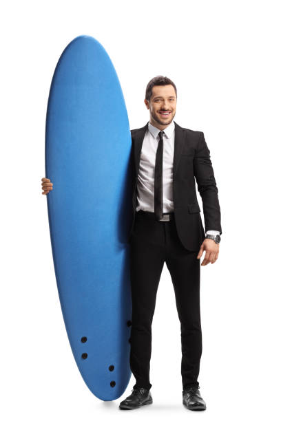 istock Young man in a suit holding a surfboard 1178520623