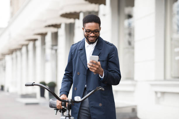 istock Way to work. Man texting on phone, standing with bike 1178523272