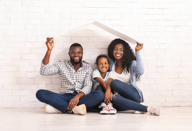 african american family sitting under roof dreaming of new home. - couple indoors studio shot horizontal imagens e fotografias de stock