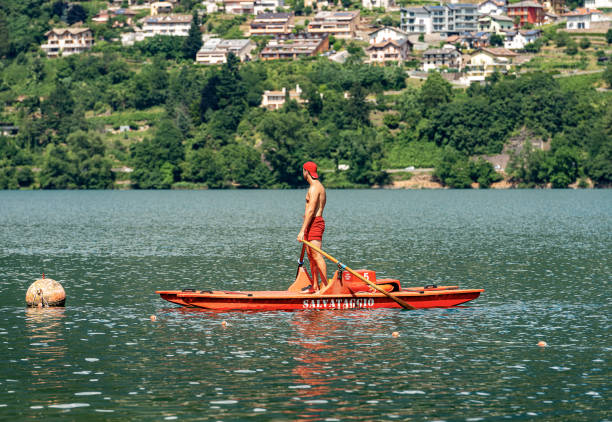 lifeguard on a orange rowing boat - caldonazzo lake italy - buoy horizontal lake sailing imagens e fotografias de stock