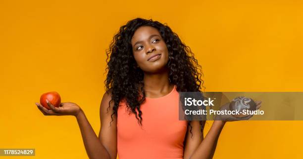 Young Woman Making Choice Donut Or Apple Stock Photo - Download Image Now - Healthy Eating, Choice, Women